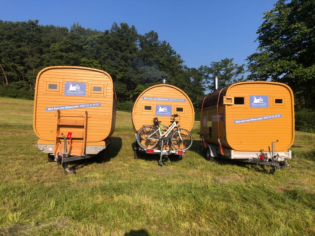 Drei Fasssaunas in unterschiedlichen Größen auf der Wiese